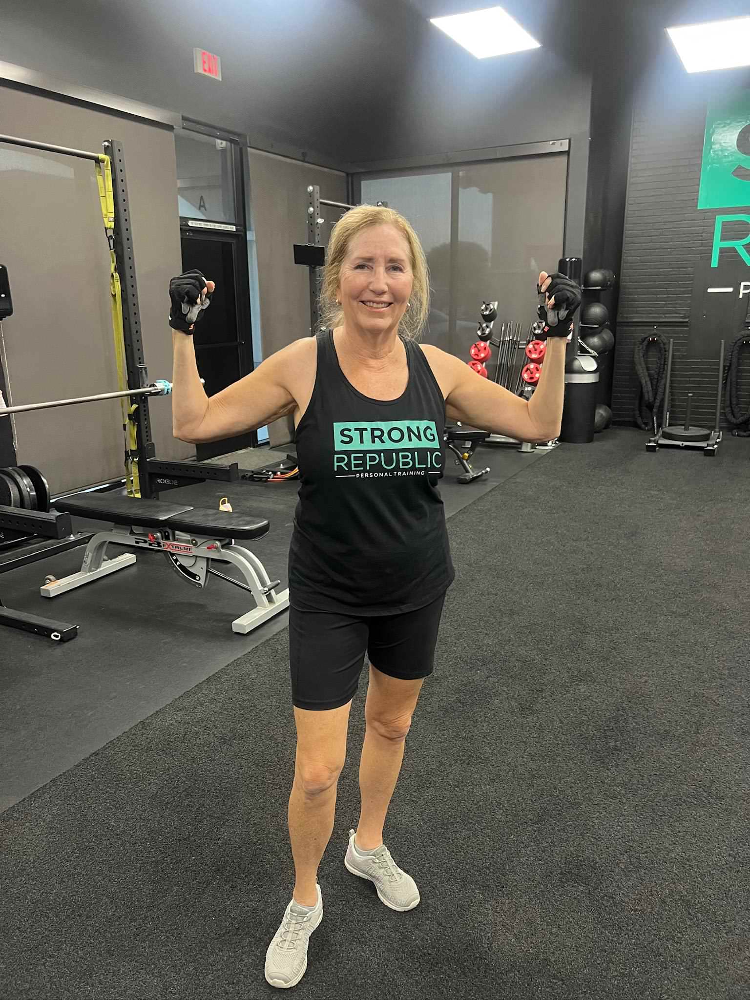 Women's personal trainer coaching adult client at Strong Republic Palm Desert gym